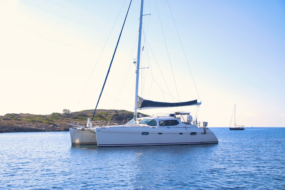 white and black sail boat on sea during daytime