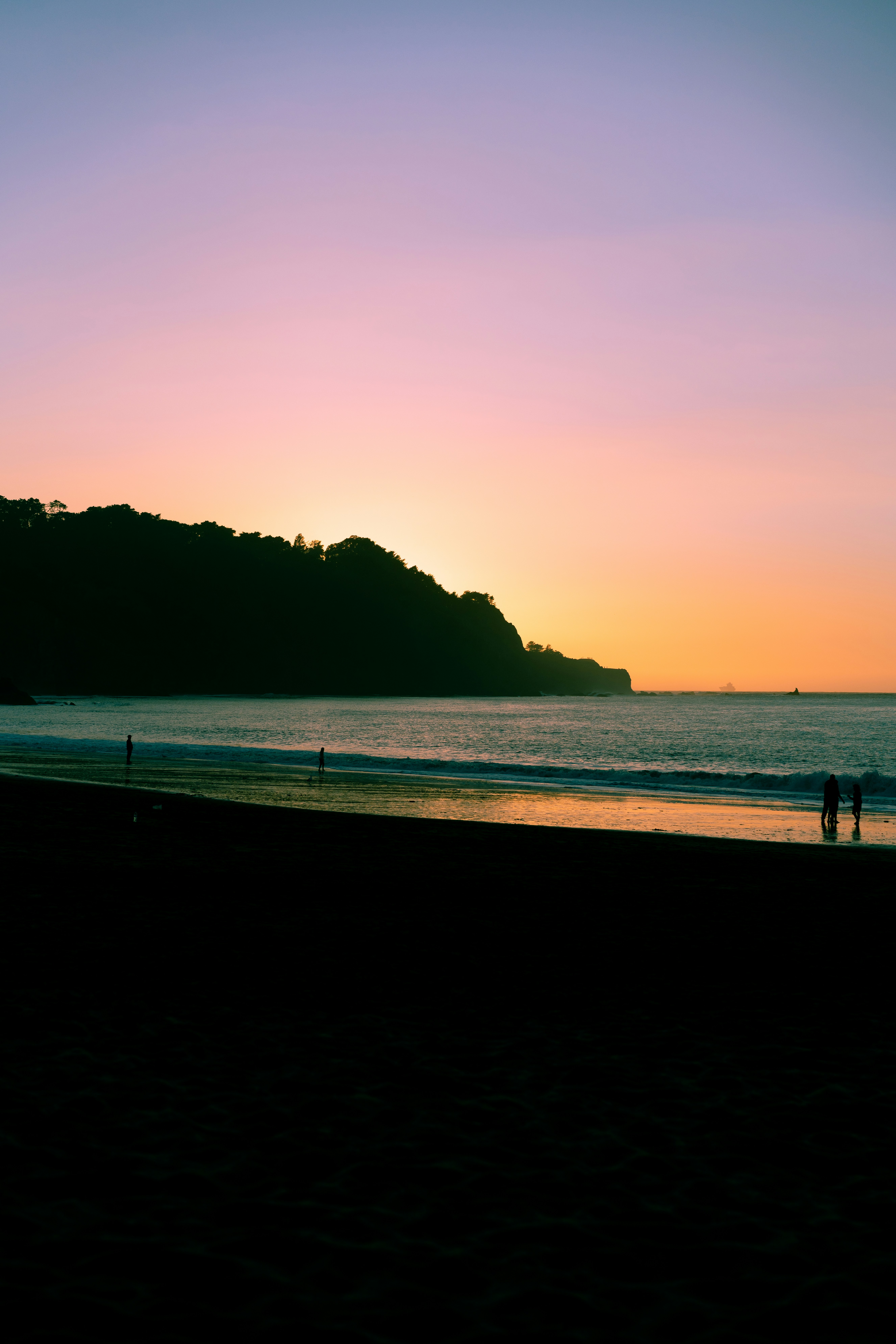 personnes sur la plage au coucher du soleil