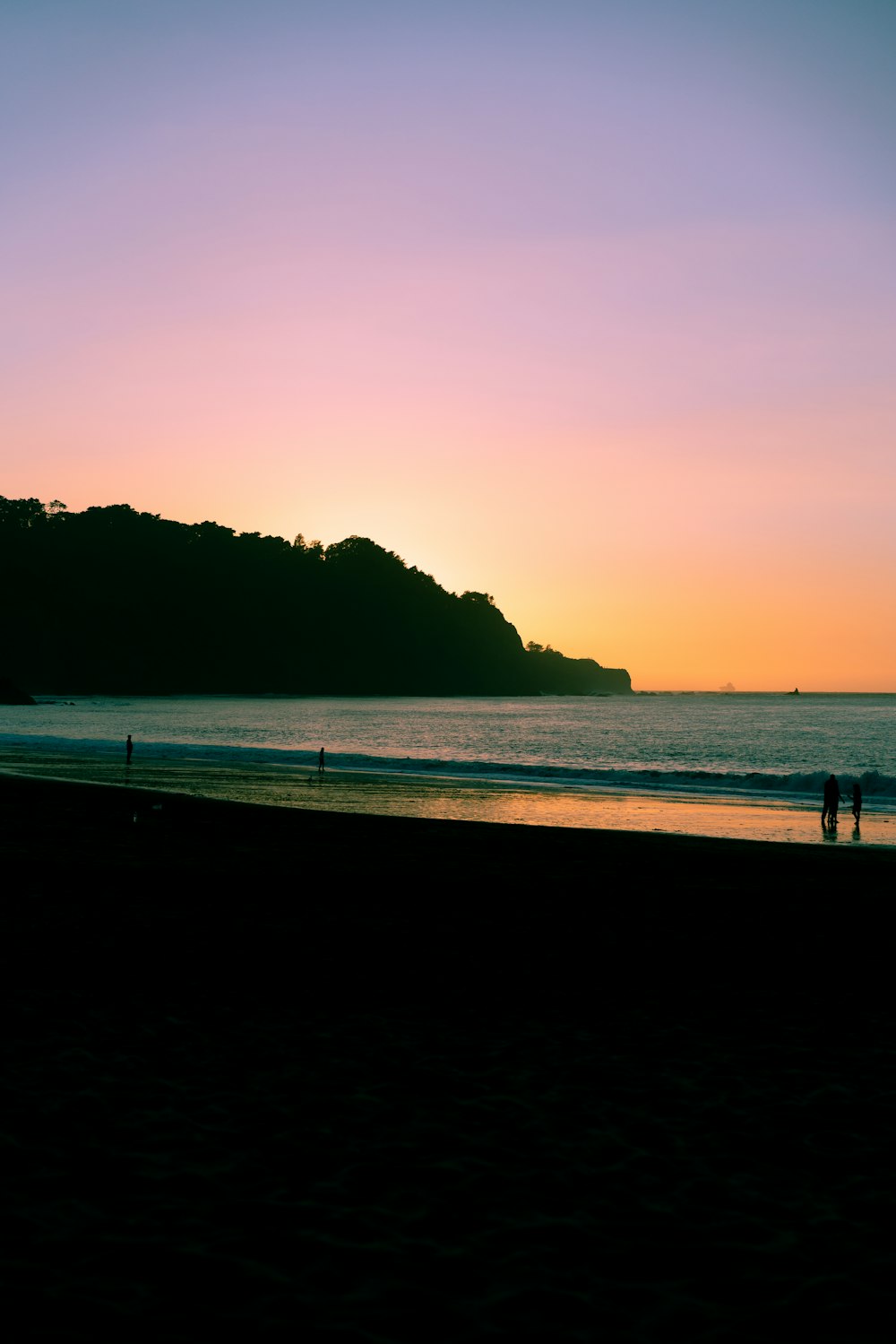 pessoas na praia durante o pôr do sol