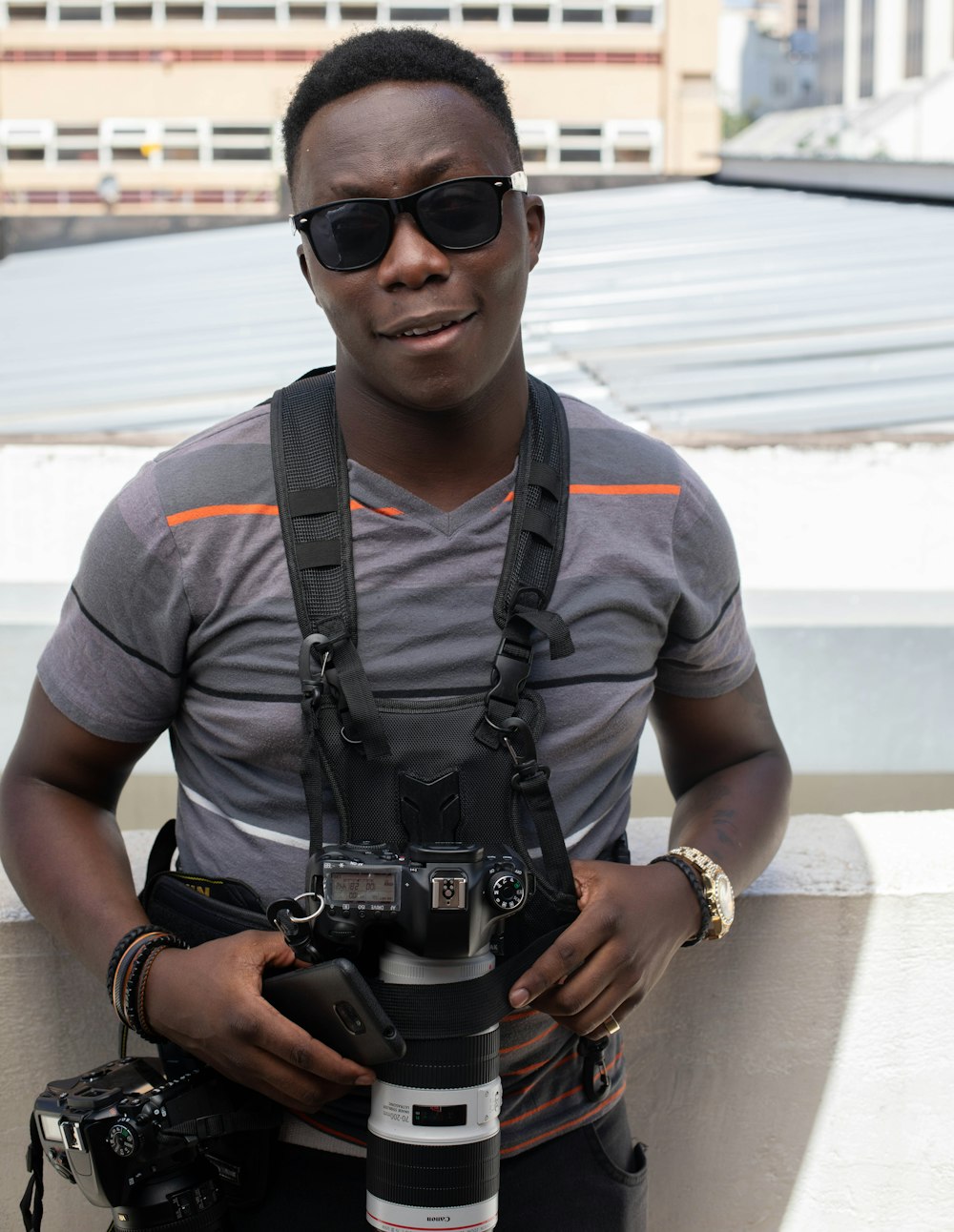 man in gray crew neck t-shirt holding black dslr camera