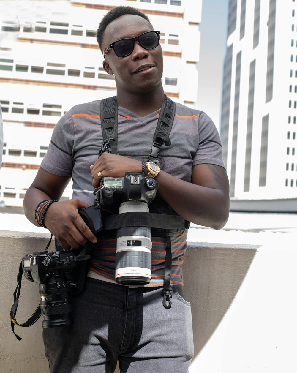 man in gray crew neck t-shirt holding black dslr camera