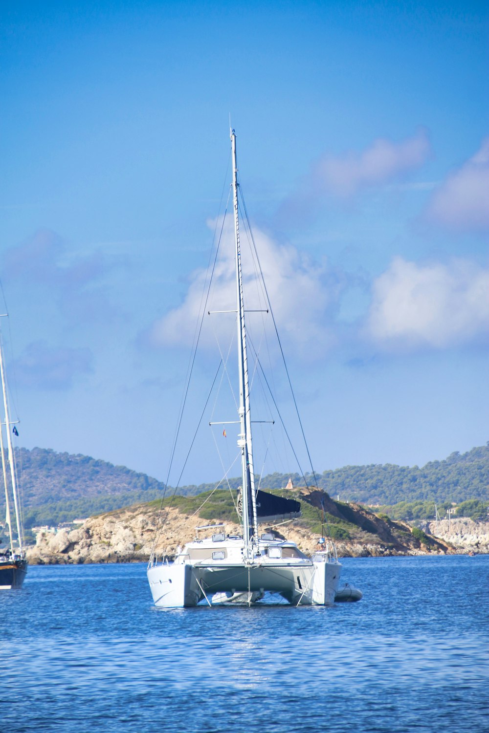 white sailboat on sea under blue sky during daytime