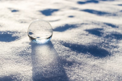 clear glass ball on white snow snowball zoom background