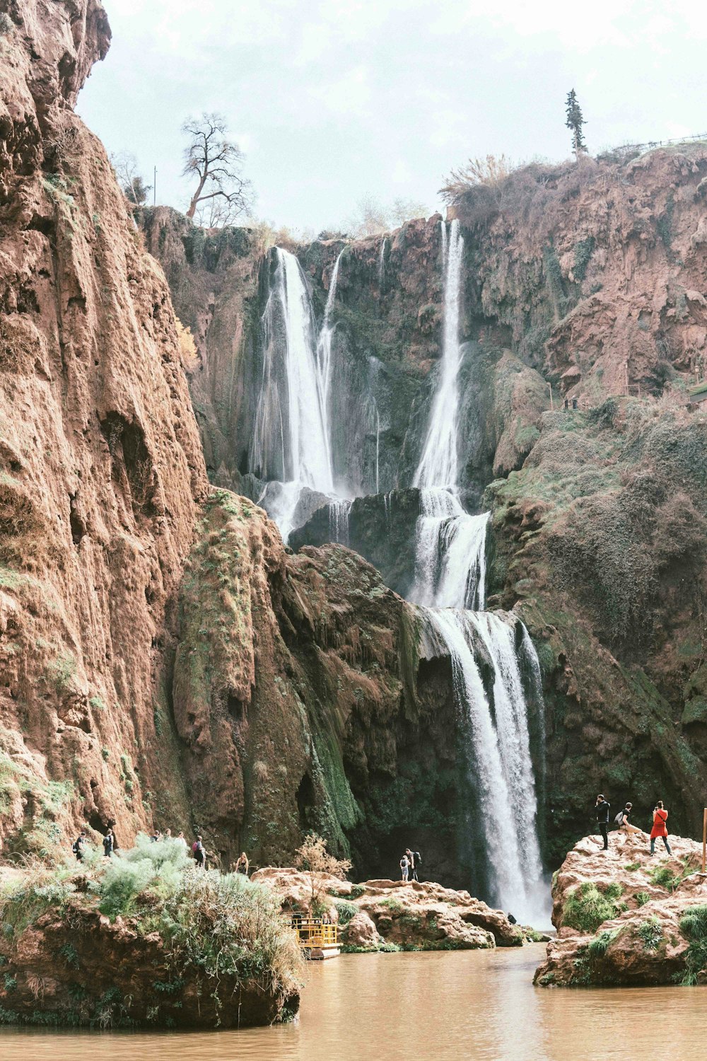 people in a waterfalls during daytime