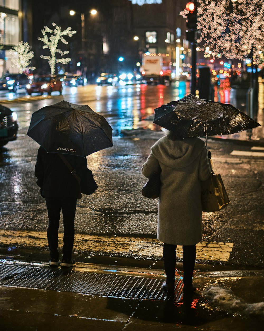 Foto pessoa em casaco preto segurando guarda-chuva andando na calçada  durante a noite – Imagem de Roupa grátis no Unsplash