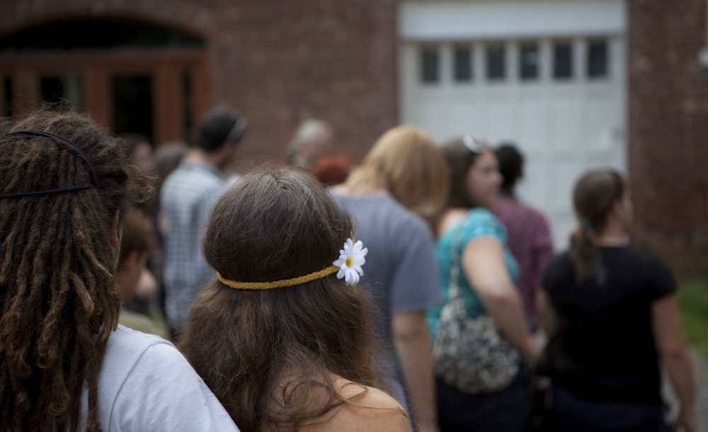 woman in white shirt with white flower on head