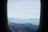 An aerial shot of a mountain range taken from an airplane window.