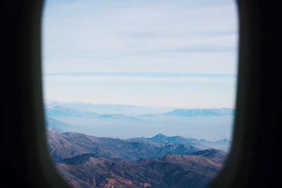 An aerial shot of a mountain range taken from an airplane window.