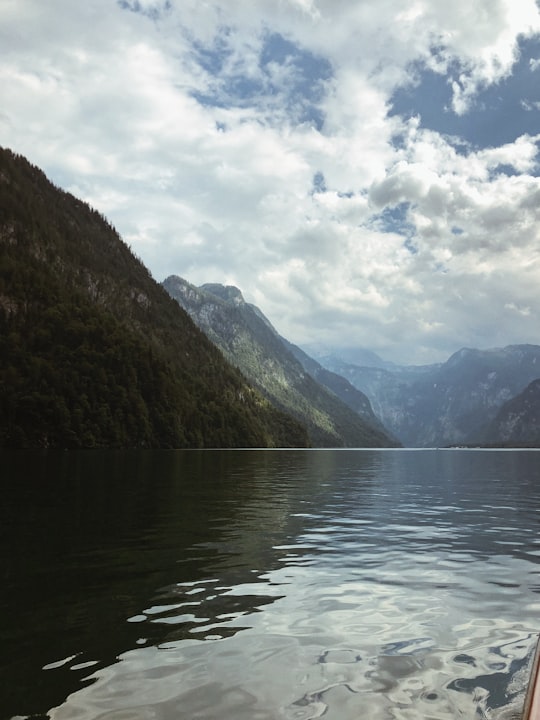 green mountains beside body of water under cloudy sky during daytime in Berchtesgaden National Park Germany