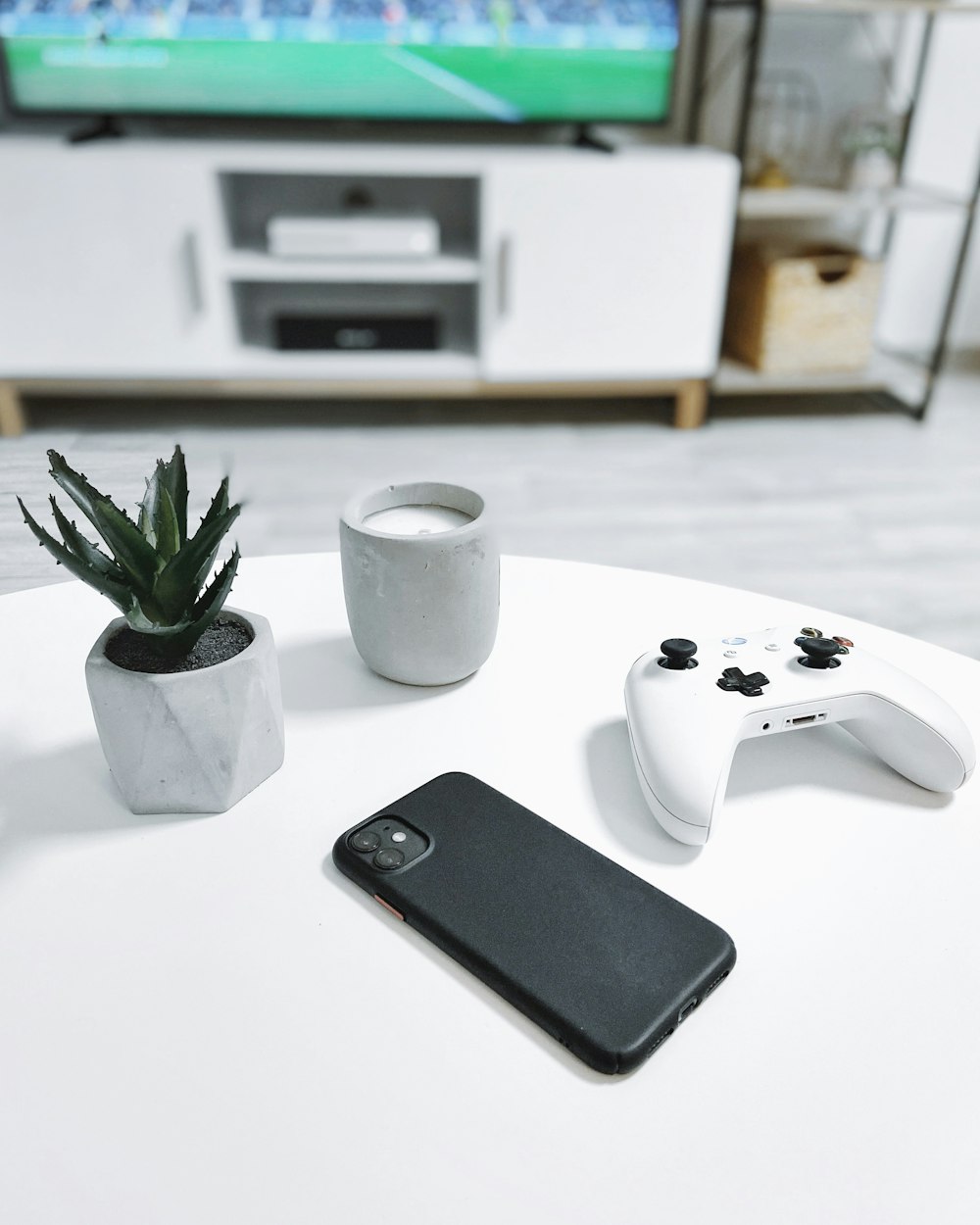 white xbox one controller beside green plant