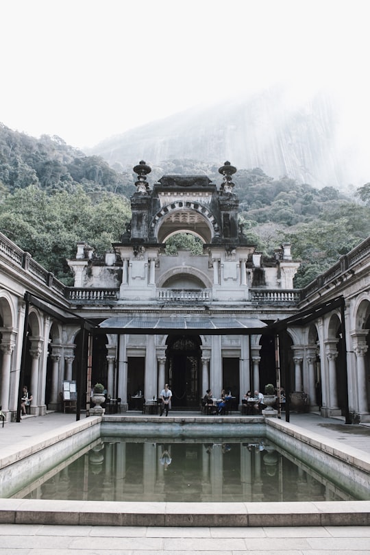 white and brown concrete building near green mountain during daytime in Parque Lage Brasil