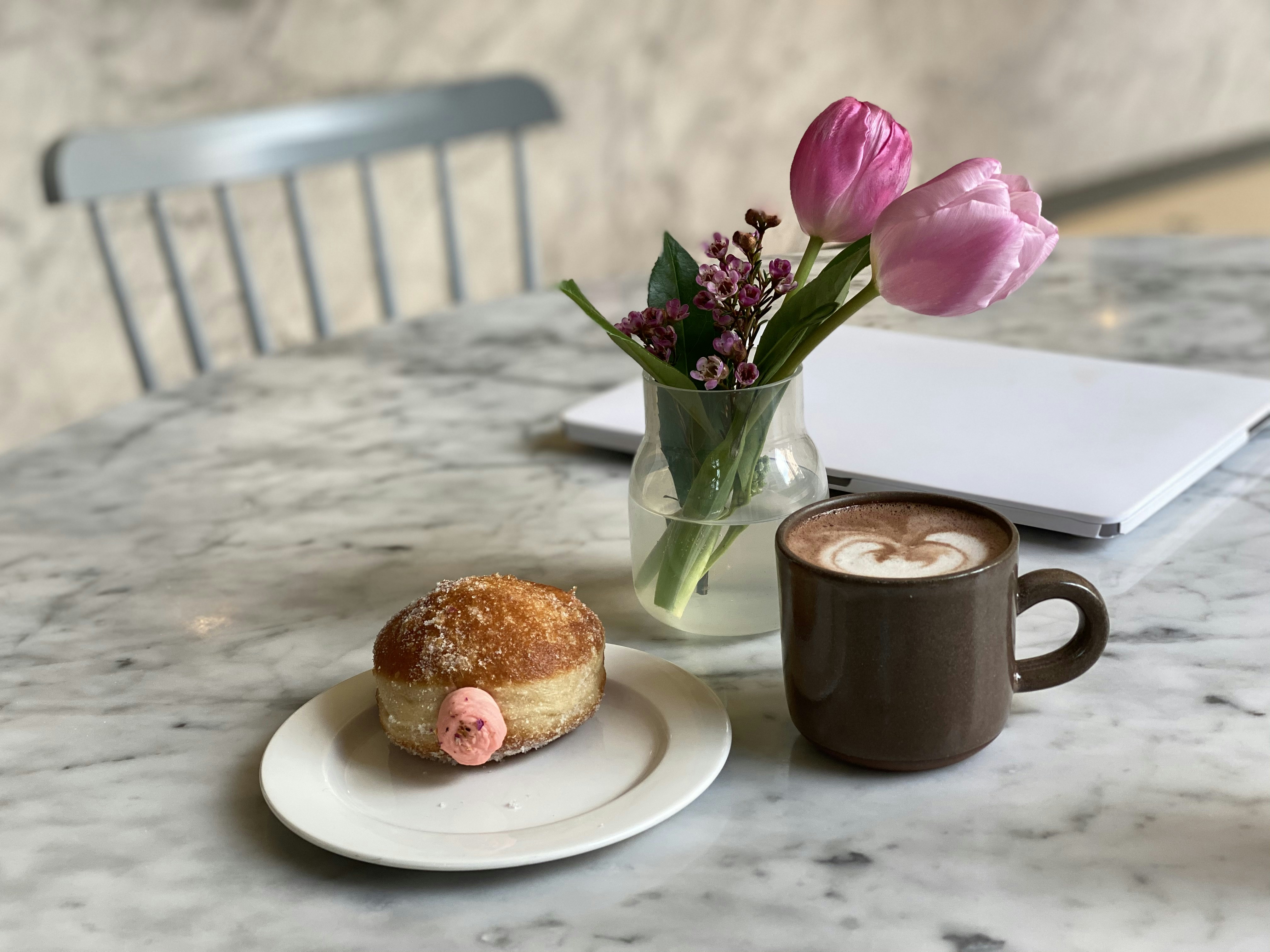 Rose donut with tulips in a work space.