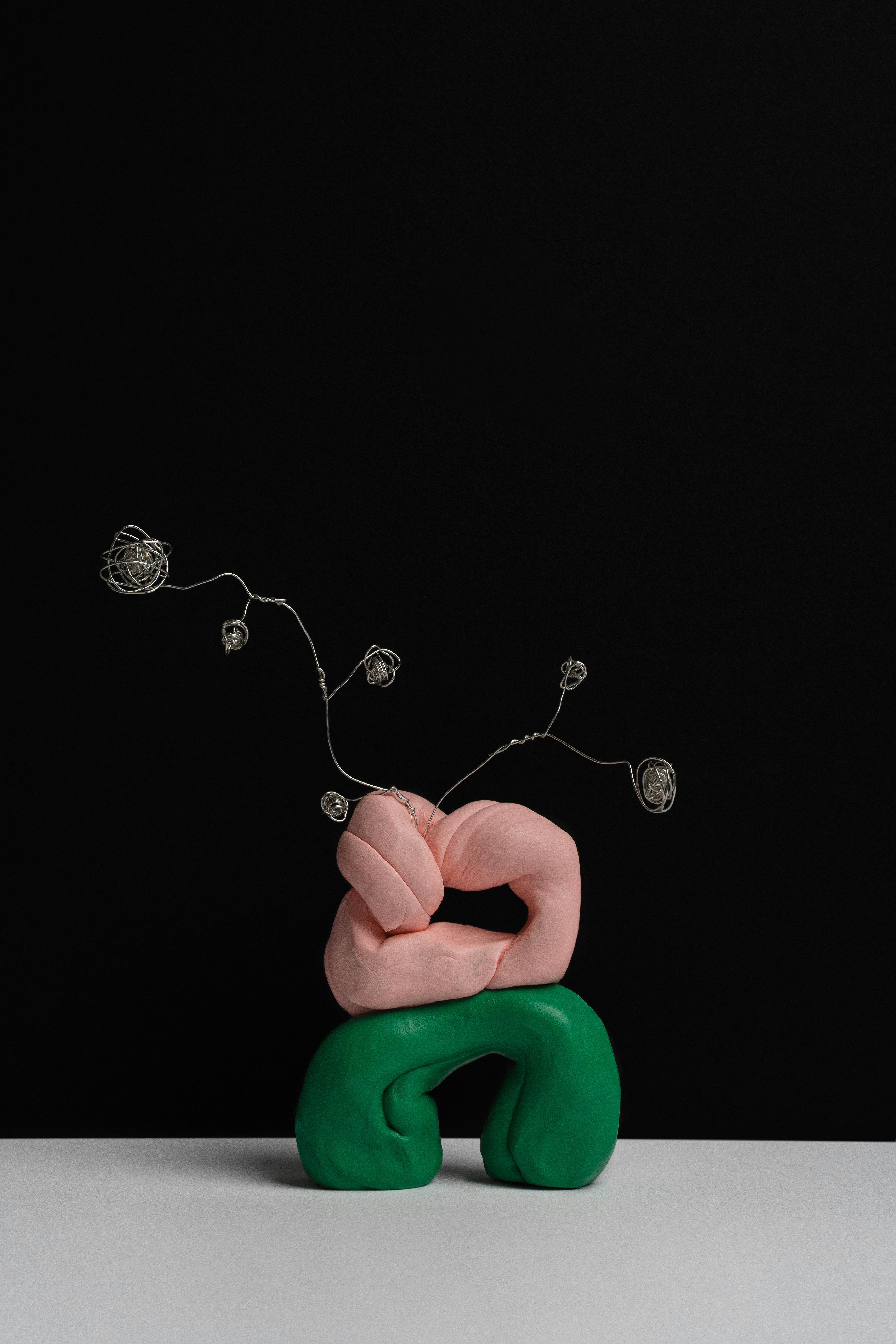 Person, die eine Halskette mit grünem herzförmigem Anhänger hält