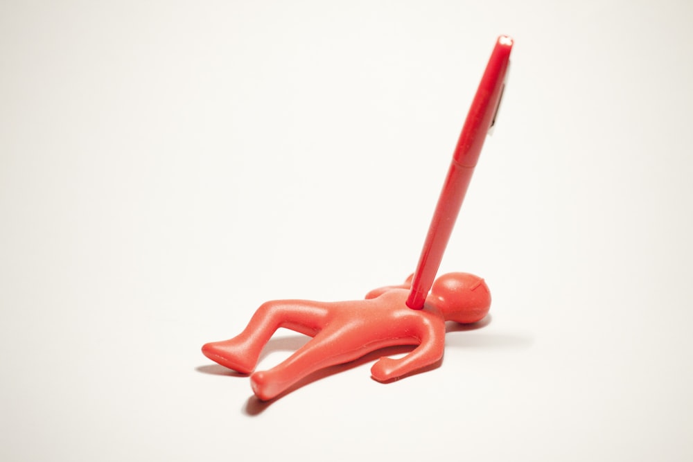 red plastic toy on white surface