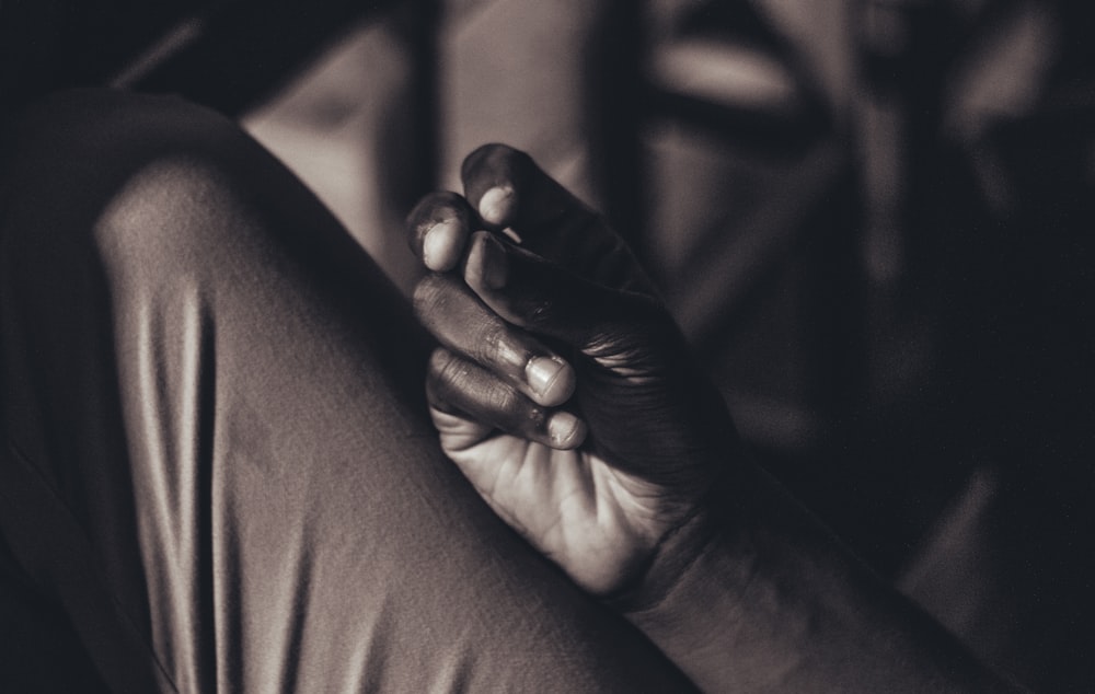 grayscale photo of person holding babys hand