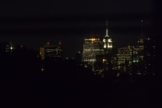 Nighttime view of Empire Tower with city lights shimmering in the background.