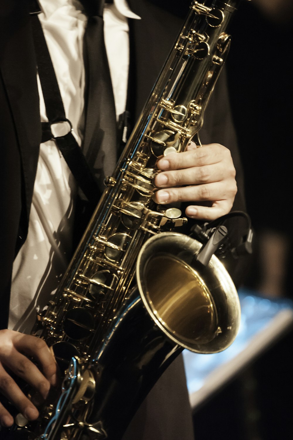 person in white dress shirt holding saxophone