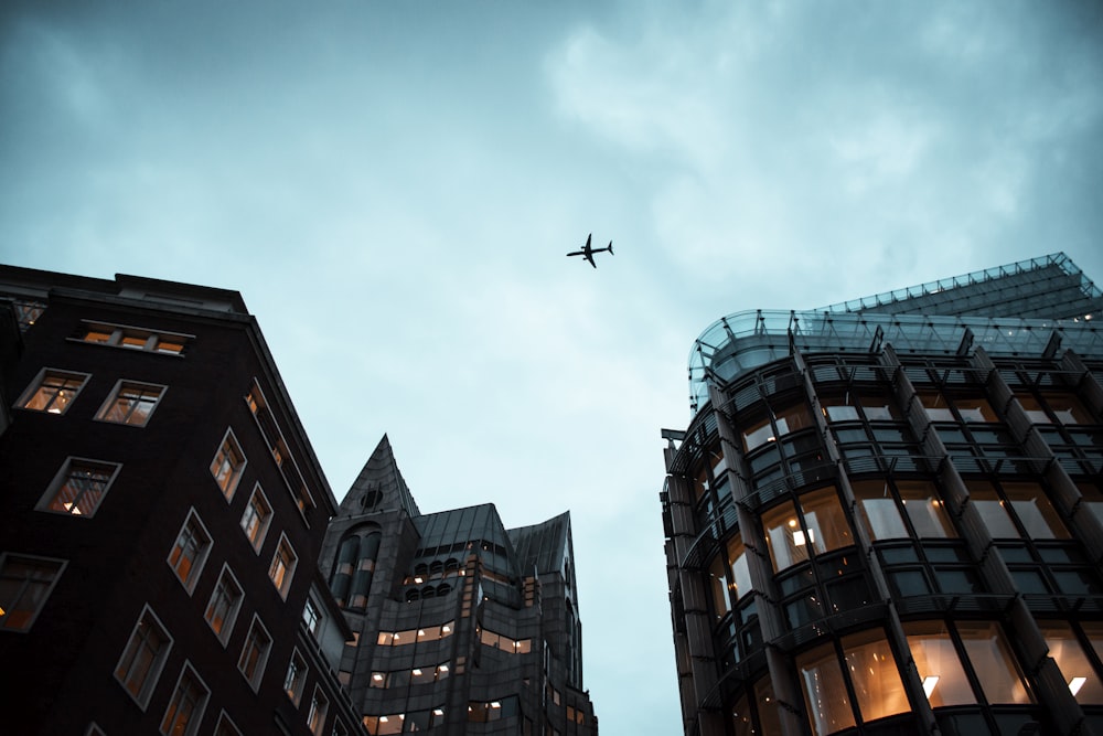 airplane flying over the building during daytime