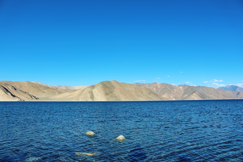 white mountains near body of water during daytime