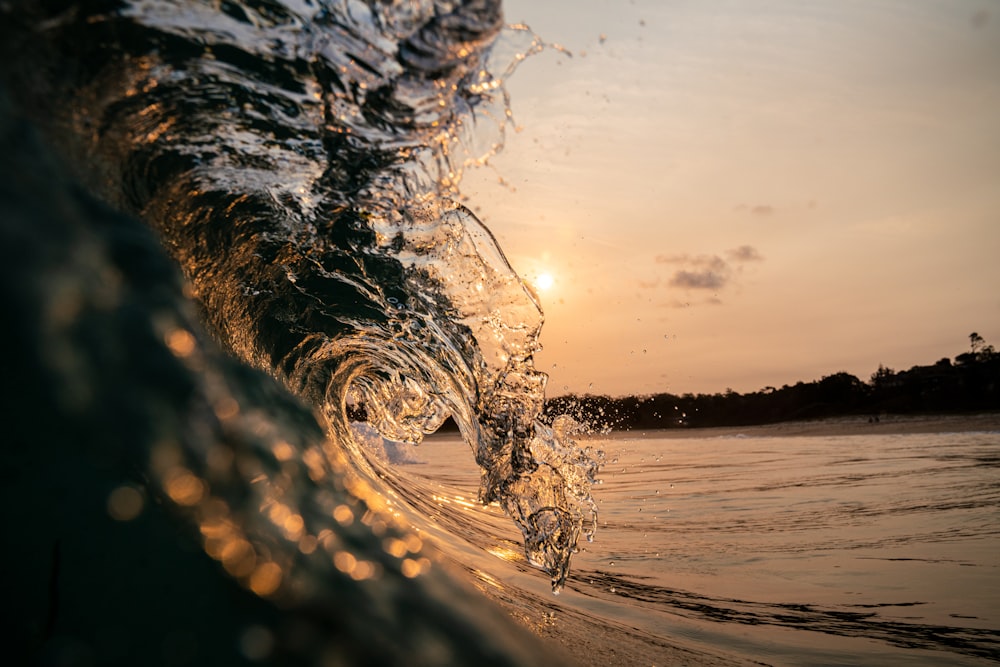 water splash on body of water during sunset