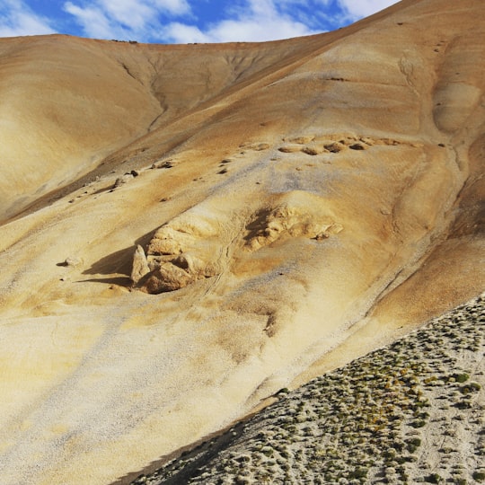 brown and white rock formation under blue sky during daytime in Ladakh India