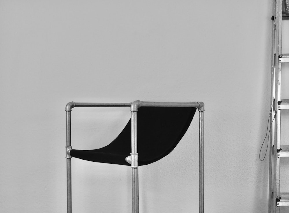 black and silver chair beside white wall