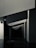 Geometric shapes and sharp angles create a modern architectural interior scene. The perspective of the image leads the eye through a series of receding plane segments, appearing as beams or dividers within the space. The lighting highlights the edges, adding depth to the darkened surroundings.