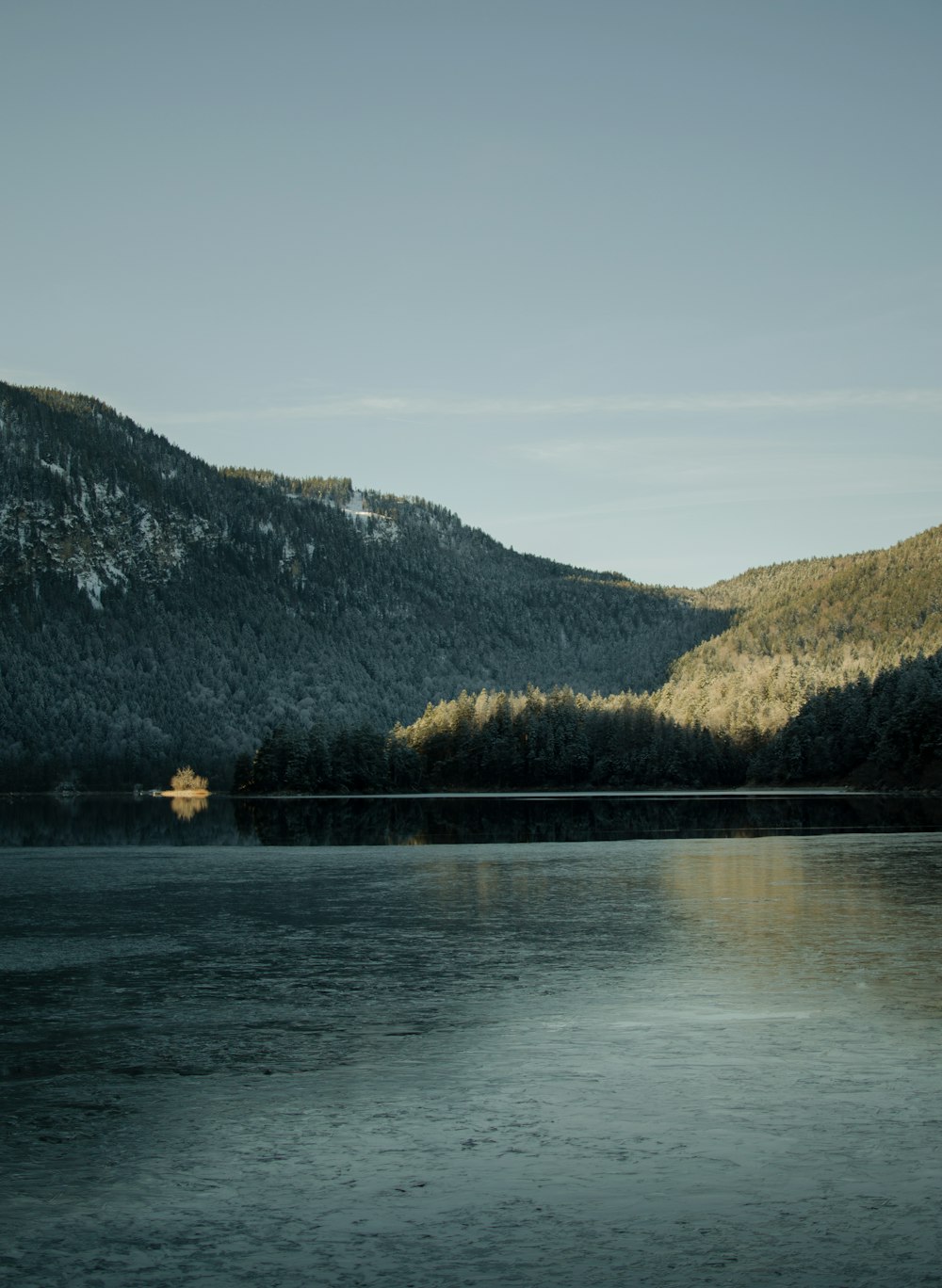 body of water near mountain during daytime