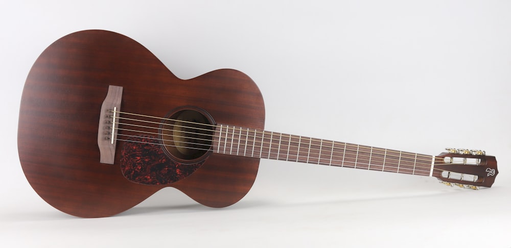 brown acoustic guitar on white background