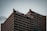 A tall office building with a grid-like pattern of windows is topped with signage that includes the words 'Heart & Stroke' and 'RBC CAN' with a red heart icon. The sky is overcast, creating a subdued atmosphere.