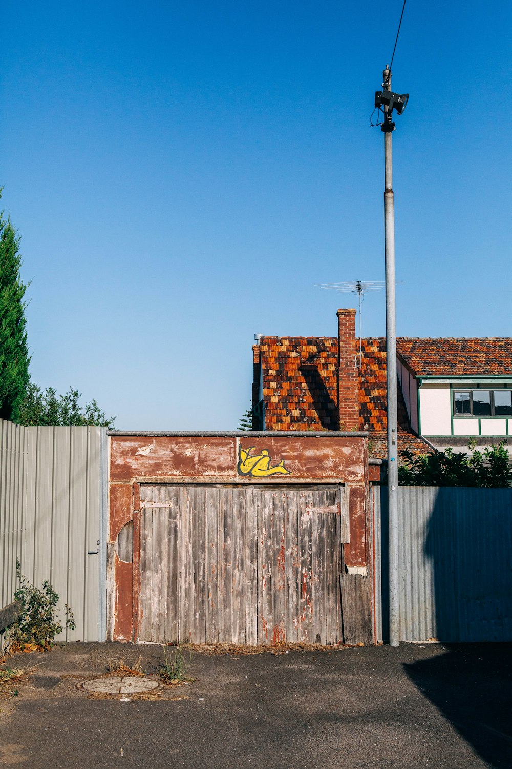 brown wooden house near green trees under blue sky during daytime