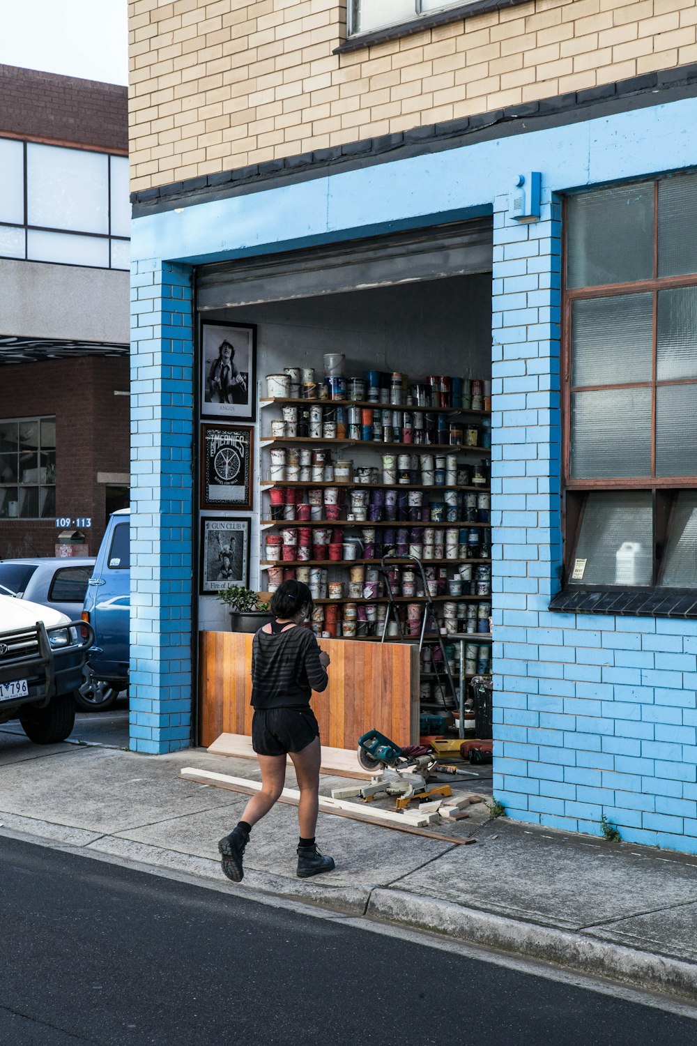 woman in black long sleeve shirt and black skirt standing in front of store during daytime