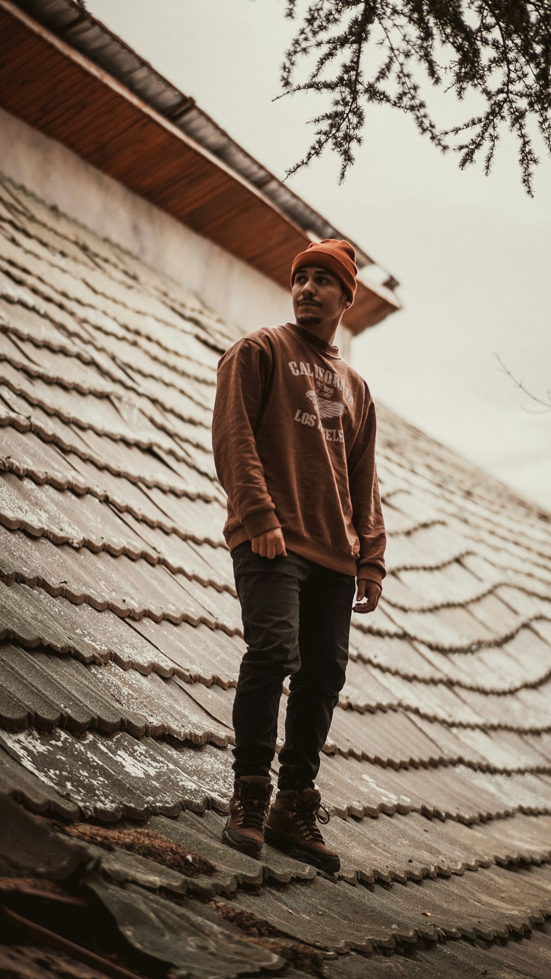 man in brown pullover hoodie standing on concrete stairs during daytime