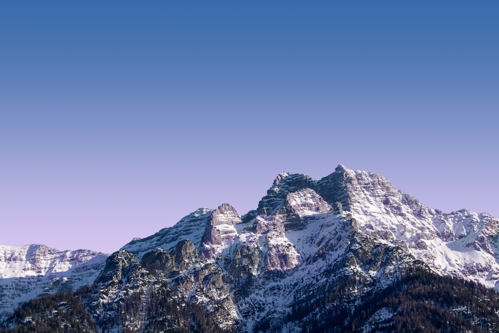 Montaña rocosa marrón y blanca bajo el cielo azul durante el día