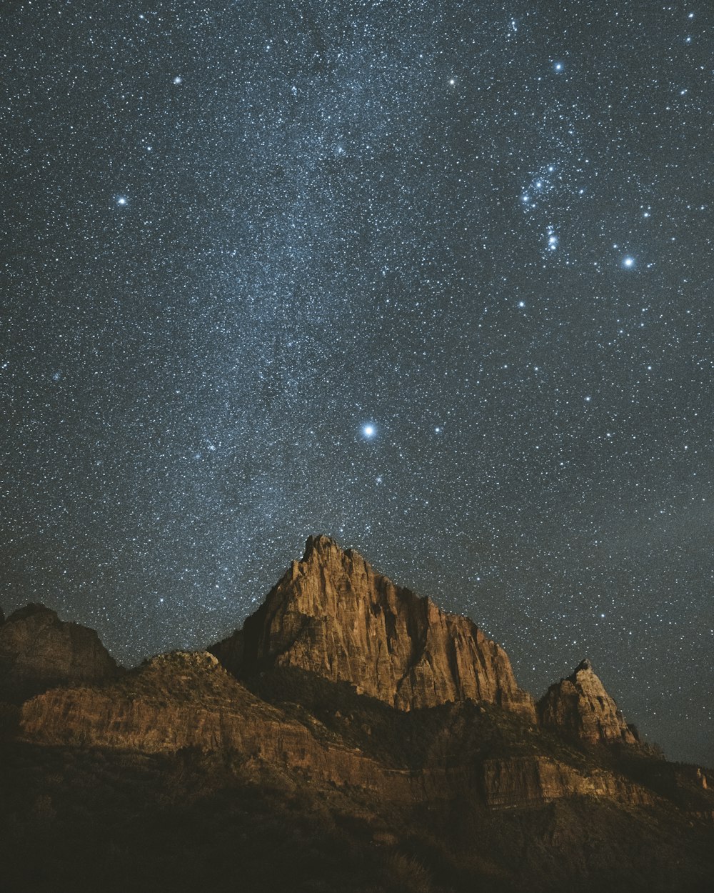 brown rocky mountain under starry night