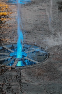 A sleek electronic water fountain for cats with a glowing blue light.