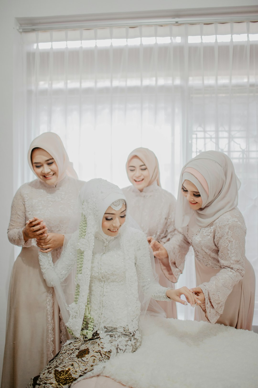 women in white hijab standing near white curtain