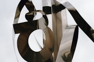 An abstract metallic sculpture with colorful light reflections in a dark room.