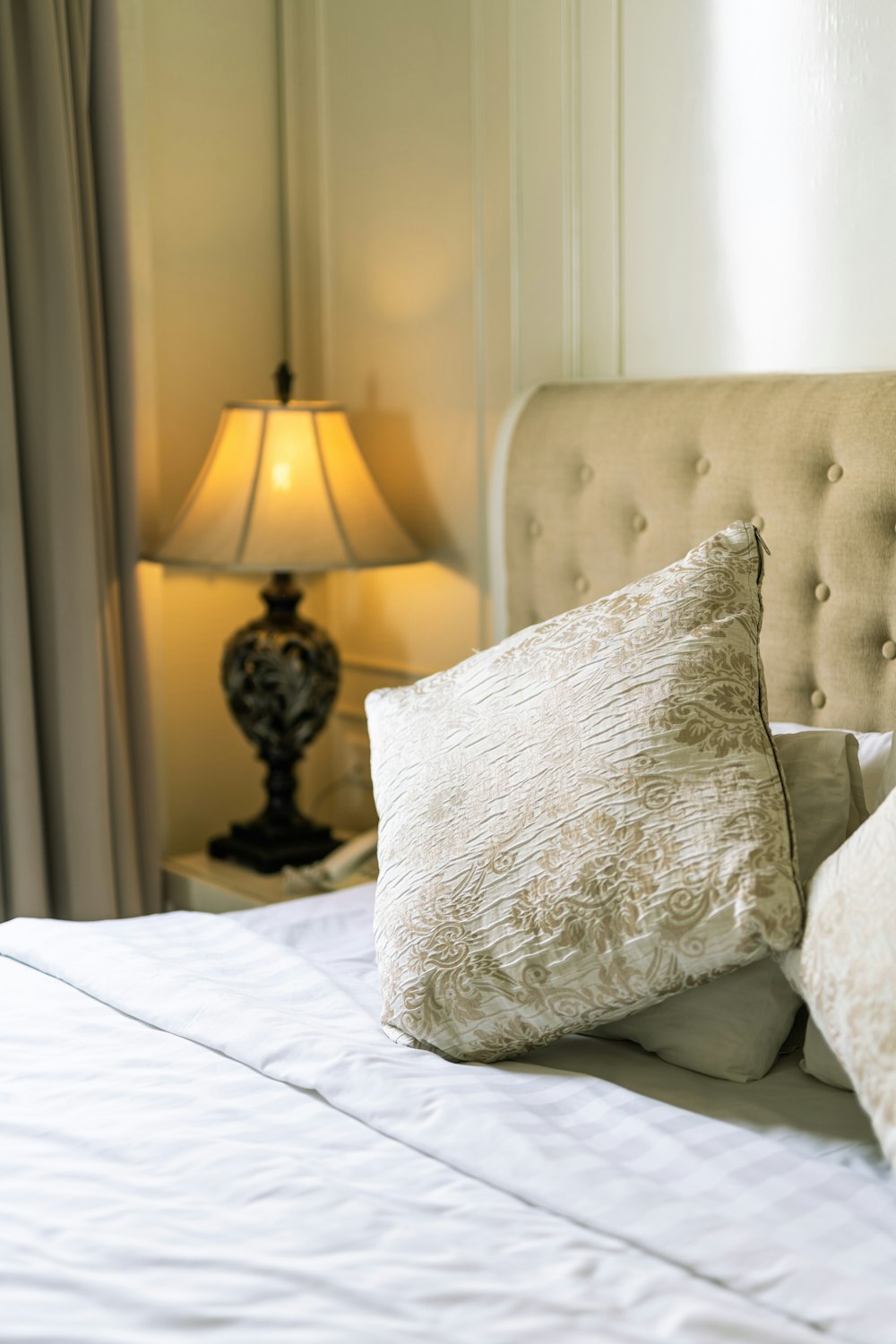 white and gray floral throw pillow on white bed