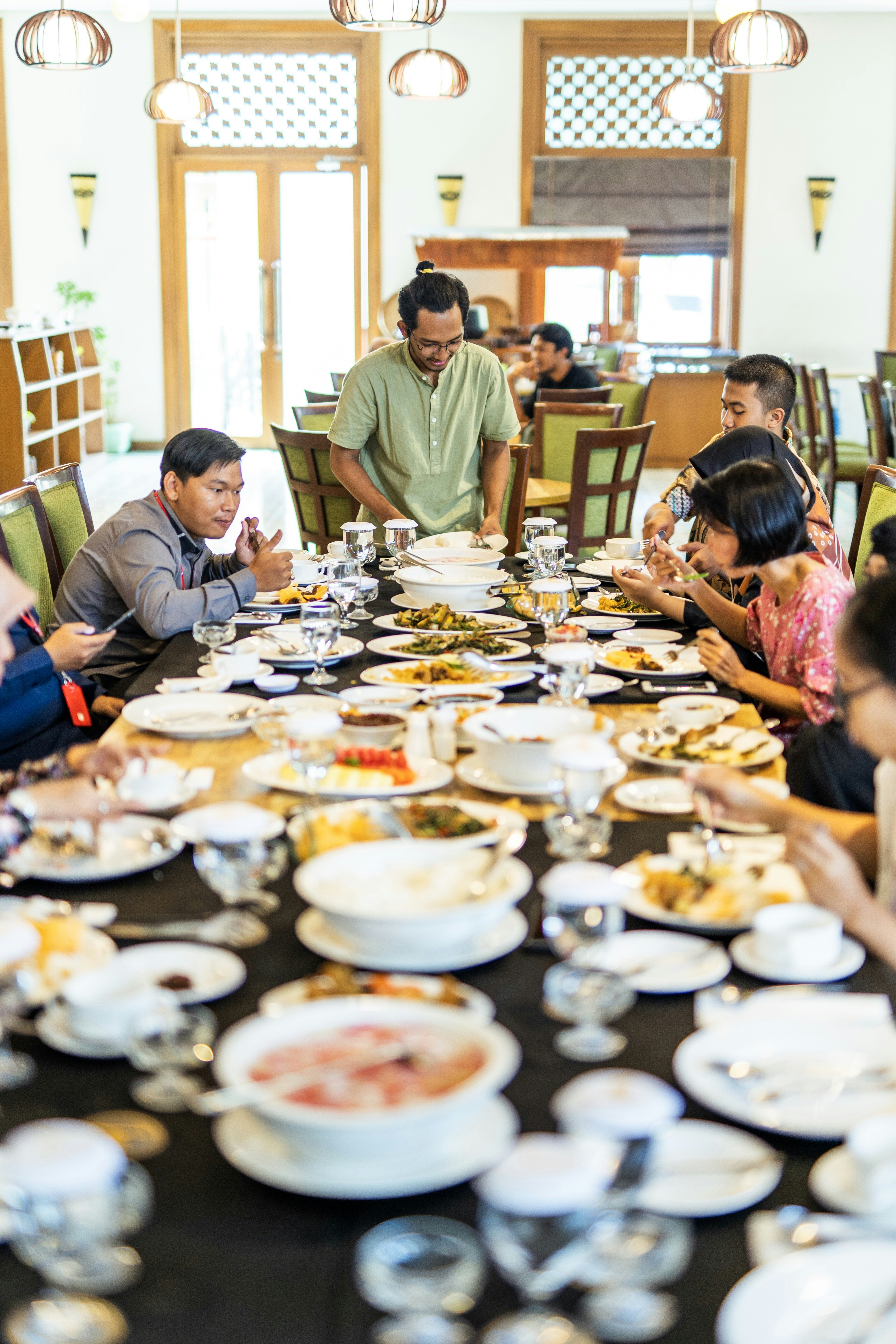 pessoas sentadas à mesa comendo