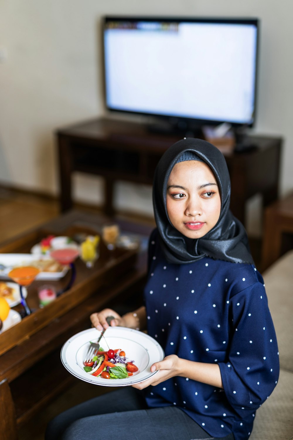 woman in blue hijab sitting by the table