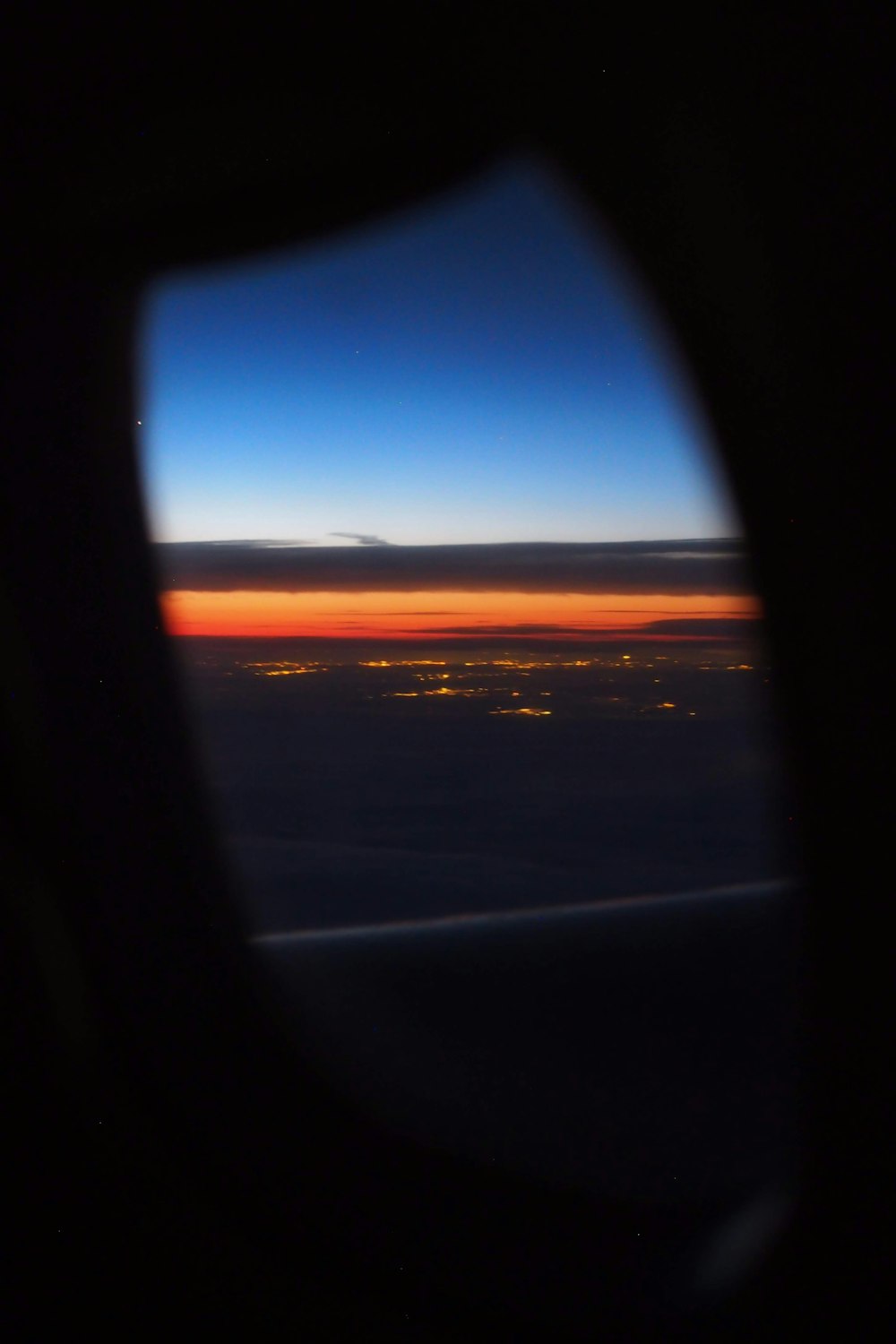 Flugzeugfensteransicht von Wolken während des Sonnenuntergangs