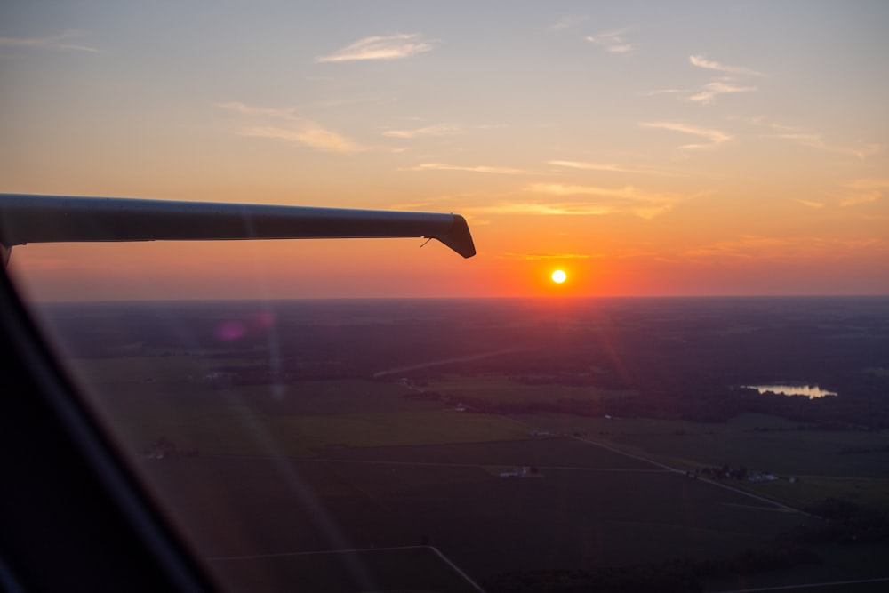 airplane wing over the city during sunset