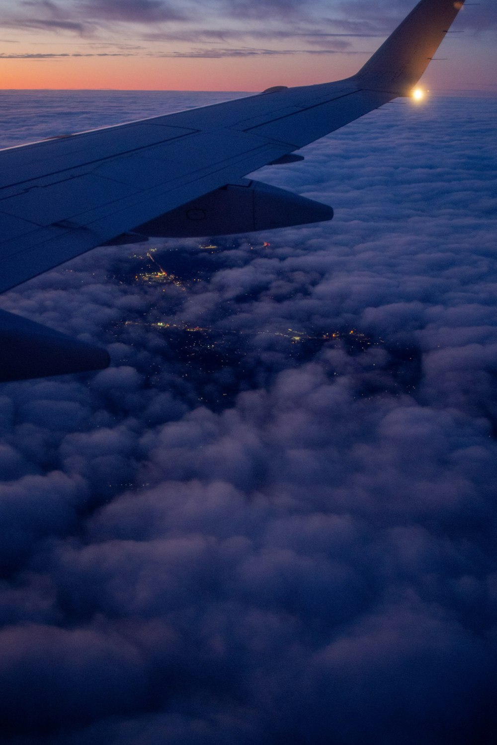 昼間の雲の上を飛ぶ飛行機の翼