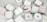 A collection of white candles, some with wooden wicks, arranged haphazardly on a flat surface. The candles are branded with 'French Candle Co' and have variations in size and shape. Some candles have lids with printed designs.