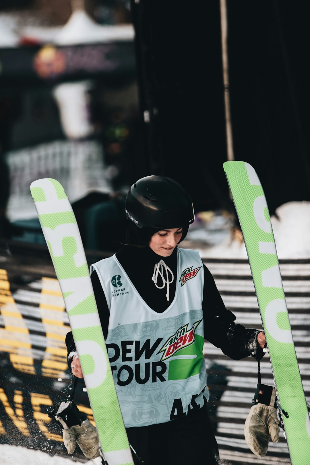 man in white and black jacket holding green and yellow snowboard