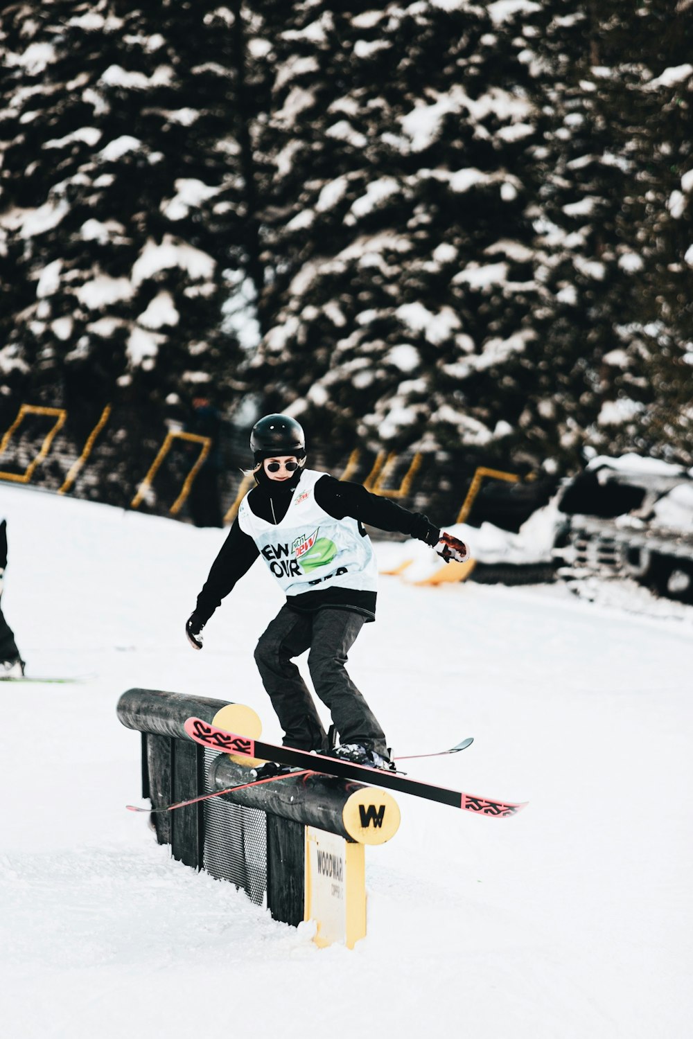 man in white and blue jacket riding red and black snow sled during daytime