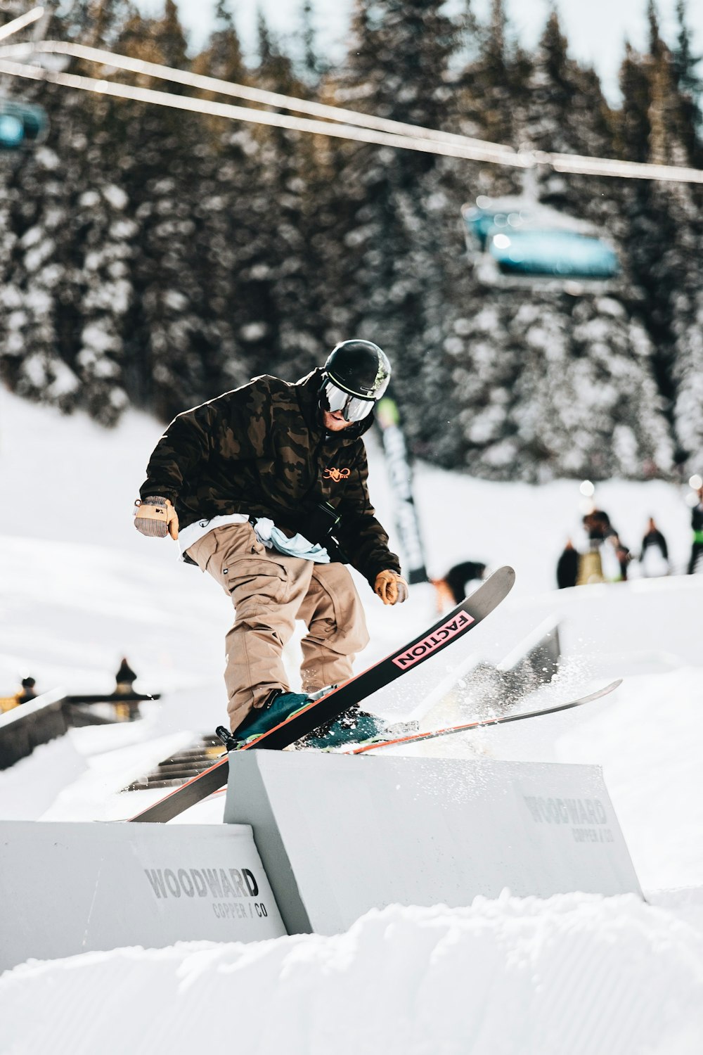 person in black jacket and red pants riding on white snowboard during daytime