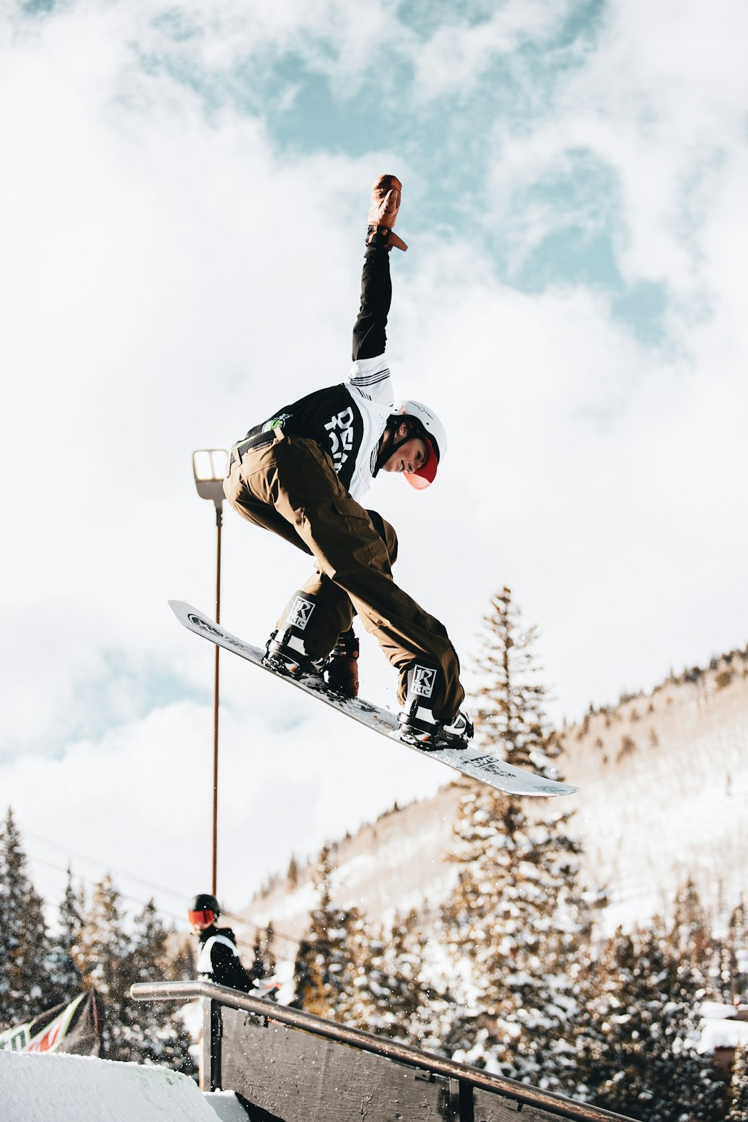 man in black and white jacket and pants riding on snowboard during daytime
