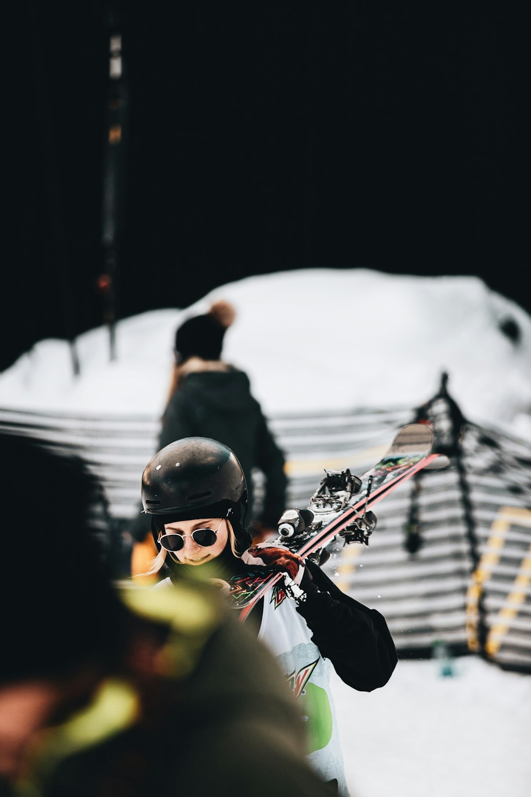 woman in black jacket and red scarf holding red and black snow ski blades